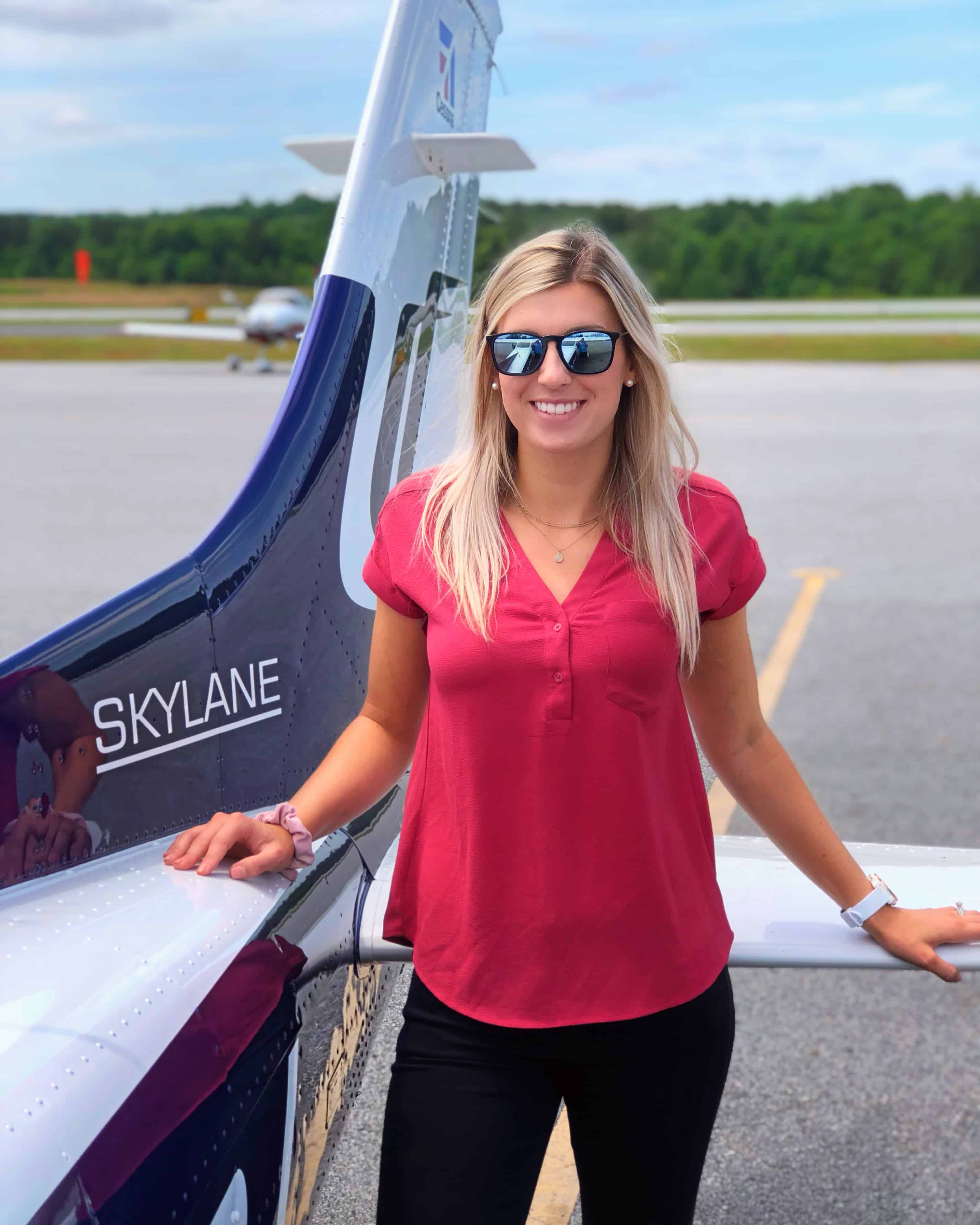 female pilot near tail of plane